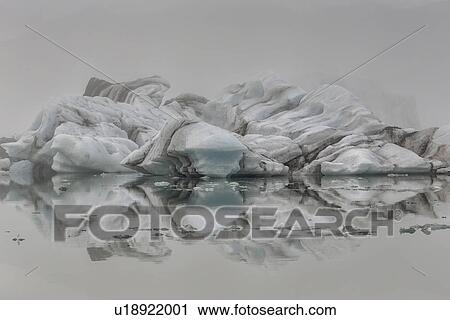Stock Image - Striped icebergs at Jokulsarlon lagoon, sunrise, Iceland. Fotosearch