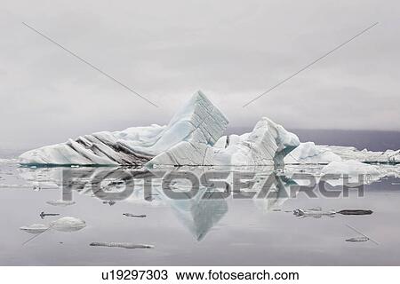Stock Image - Striped icebergs at Jokulsarlon lagoon, misty sunrise, Iceland. Fotosearch