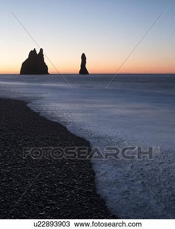 Stock Image - Sunrise over Dyrholaey sea stacks, Iceland. Fotosearch
