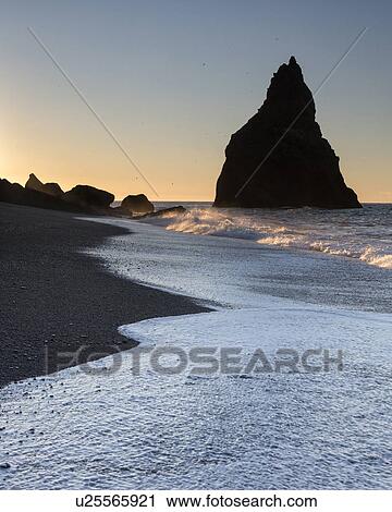 Stock Image - Sunrise over Dyrholaey sea stacks, Iceland. Fotosearch