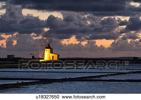 Stock Image - Windmills at Trapani saline pans, twilight, Sicily, Italy. Fotosearch
