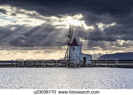 Stock Image - Windmills at Trapani saline pans, sunset, Sicily, Italy. Fotosearch