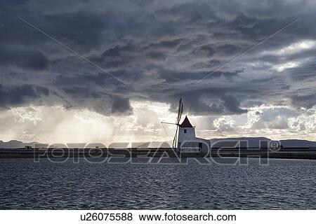 Stock Photo - Windmills at Trapani saline pans, sunset, Sicily, Italy. Fotosearch