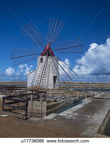 Stock Photograph - Windmills at Trapani saline pans, Sicily, Italy. Fotosearch
