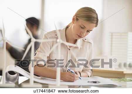 Stock Photo - Architect working in firm dealing with wind power. Fotosearch