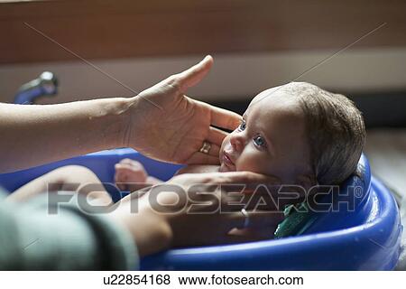Baby (2-5 months) bathing in baby bathtub View Large Photo Image Stock Photo - Baby (2-5 months) bathing in baby bathtub . Fotosearch