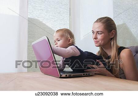 Baby girl (12-17 months) and mother using laptop View Large Photo Image Stock Photo - Baby girl (12-17 months) and mother using laptop. Fotosearch