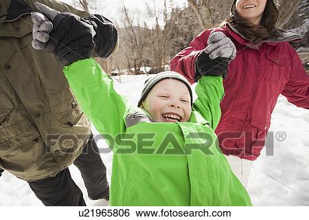 Stock Photograph - Boy (4-5) with parents during stroll. Fotosearch