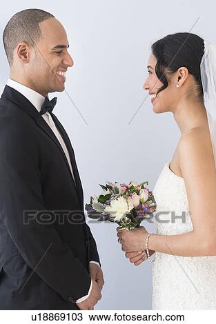 Stock Image - Bride and groom standing face to face. Fotosearch