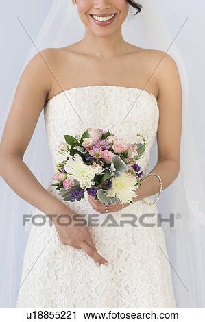 Bride in veil holding bouquet and crossing fingers View Large Photo Image Stock Image - Bride in veil holding bouquet and crossing fingers. Fotosearch