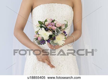 Bride in veil holding bouquet View Large Photo Image Stock Photography - Bride in veil holding bouquet. Fotosearch