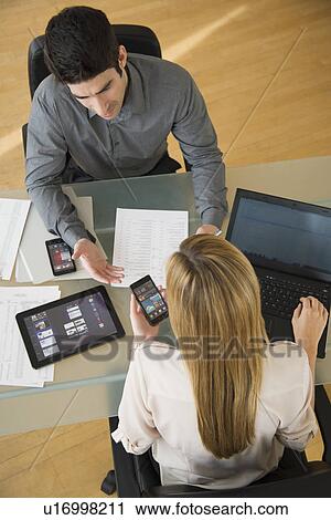 Business man and woman using mobile devices View Large Photo Image Stock Image - Business man and woman using mobile devices. Fotosearch