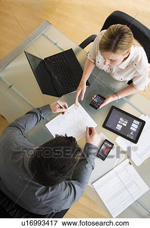 Business man and woman using mobile devices View Large Photo Image Stock Photo - Business man and woman using mobile devices. Fotosearch