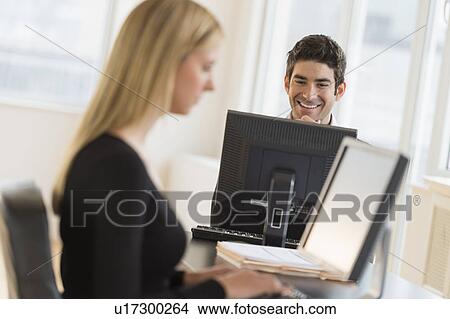 Picture - Business man and woman working in office. Fotosearch