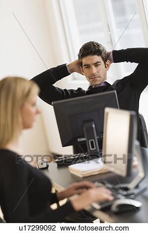 Stock Image - Business man and woman working in office. Fotosearch