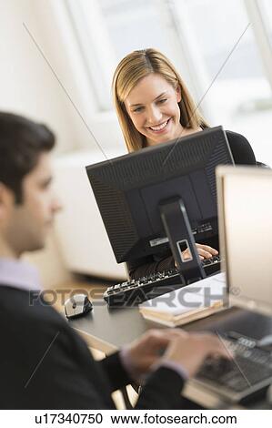 Stock Image - Business man and woman working in office. Fotosearch