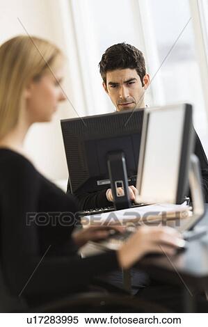 Stock Photography - Business man and woman working in office. Fotosearch