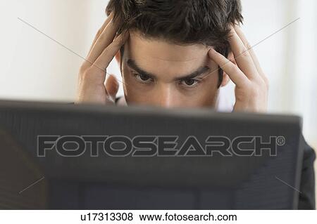 Stock Photo - Business man with head in hands. Fotosearch