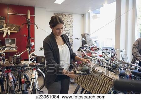 Picture - Business owner pricing bike basket in store. Fotosearch