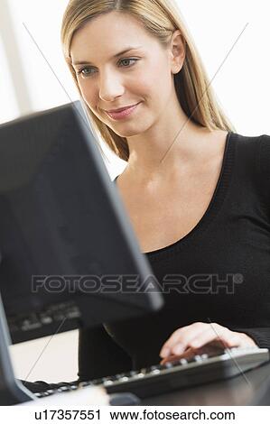 Stock Image - Business woman looking at computer. Fotosearch