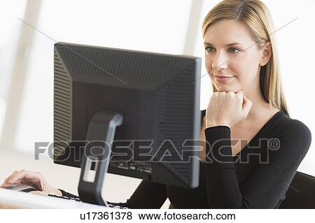 Business woman looking at computer View Large Photo Image Stock Photo - Business woman looking at computer. Fotosearch