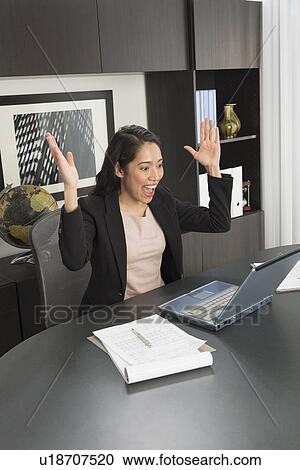 Businesswoman expressing happiness at desk View Large Photo Image Stock Image - Businesswoman expressing happiness at desk. Fotosearch