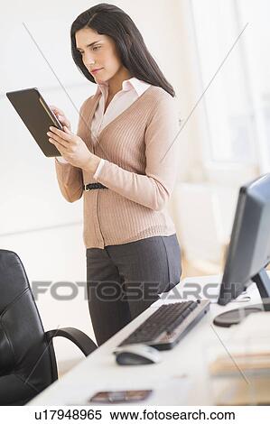 Businesswoman using digital tablet in office View Large Photo Image Stock Photography - Businesswoman using digital tablet in office. Fotosearch