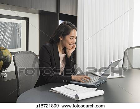 Businesswoman working at desk in office View Large Photo Image Stock Photo - Businesswoman working at desk in office. Fotosearch