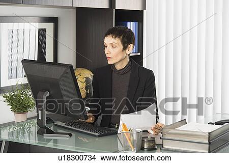 Businesswoman working at desk View Large Photo Image Picture - Businesswoman working at desk. Fotosearch