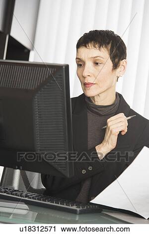 Businesswoman working at desk View Large Photo Image Stock Image - Businesswoman working at desk. Fotosearch