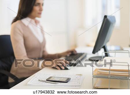 Stock Image - Businesswoman working on computer. Fotosearch