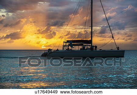 Stock Photo - Catamaran on sea at sunset. Fotosearch
