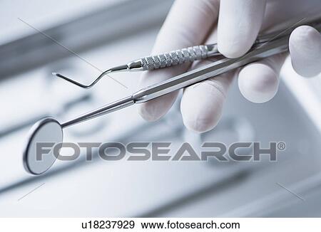 Close up of hand in surgical glove holding dental tools, studio shot View Large Photo Image Stock Photo - Close up of hand in surgical glove holding dental tools, studio shot. Fotosearch