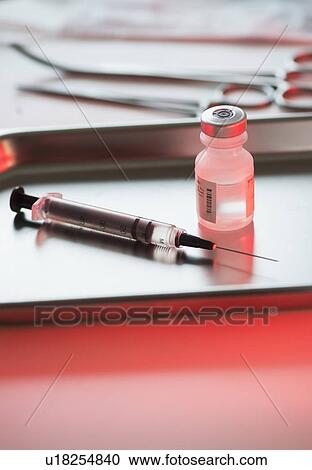 Stock Image - Close up of syringe and medication, studio shot. Fotosearch