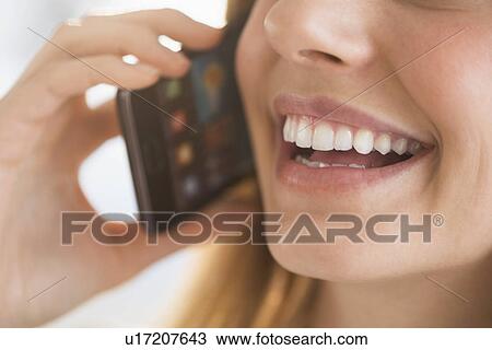 Close-up of woman talking on phone View Large Photo Image Stock Image - Close-up of woman talking on phone. Fotosearch