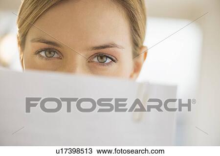 Stock Image - Close-up of young woman reading documents. Fotosearch