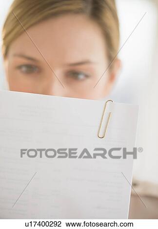 Close-up of young woman reading documents View Large Photo Image Stock Image - Close-up of young woman reading documents. Fotosearch
