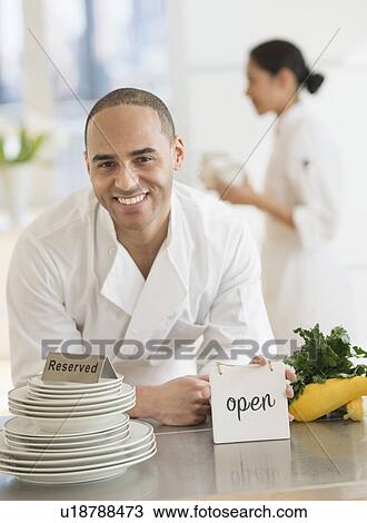 Couple during preparations in kitchen of their own restaurant View Large Photo Image Stock Image - Couple during preparations in kitchen of their own restaurant. Fotosearch