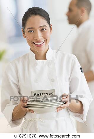 Stock Image - Couple during preparations in kitchen of their own restaurant. Fotosearch