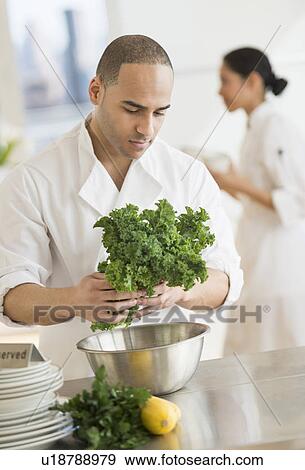 Couple during preparations in kitchen of their own restaurant View Large Photo Image Stock Photo - Couple during preparations in kitchen of their own restaurant. Fotosearch