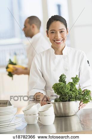 Stock Photograph - Couple during preparations in kitchen of their own restaurant. Fotosearch