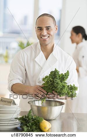 Stock Photography - Couple during preparations in kitchen of their own restaurant. Fotosearch