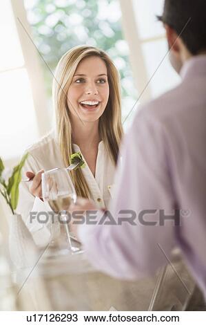 Stock Image - Couple eating dinner in restaurant. Fotosearch