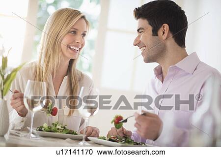 Stock Image - Couple eating dinner in restaurant. Fotosearch
