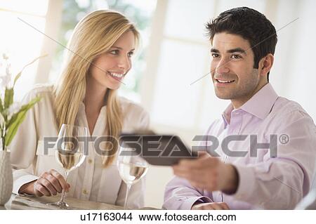 Couple in restaurant, man paying View Large Photo Image Picture - Couple in restaurant, man paying. Fotosearch