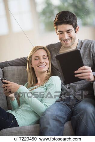 Stock Image - Couple using tablet pc and smartphone. Fotosearch
