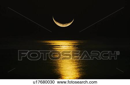 Stock Image - Crescent moon reflecting in sea. Fotosearch