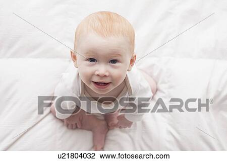 Directly above portrait of baby boy (18-23 months) sitting on duvet and looking at camera View Large Photo Image Stock Image - Directly above portrait of baby boy (18-23 months) sitting on duvet and looking at camera. Fotosearch