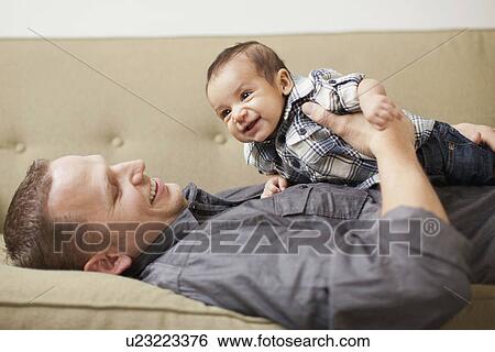 Stock Photograph - Father holding his son (2-5months). Fotosearch