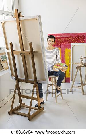 Female artist painting in her studio View Large Photo Image Picture - Female artist painting in her studio. Fotosearch